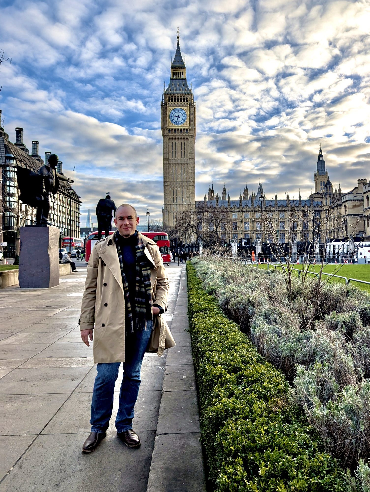 Erik in a trench coat in Parliament Square, London, with Big Ben and the Houses of Parliament rising behind him.