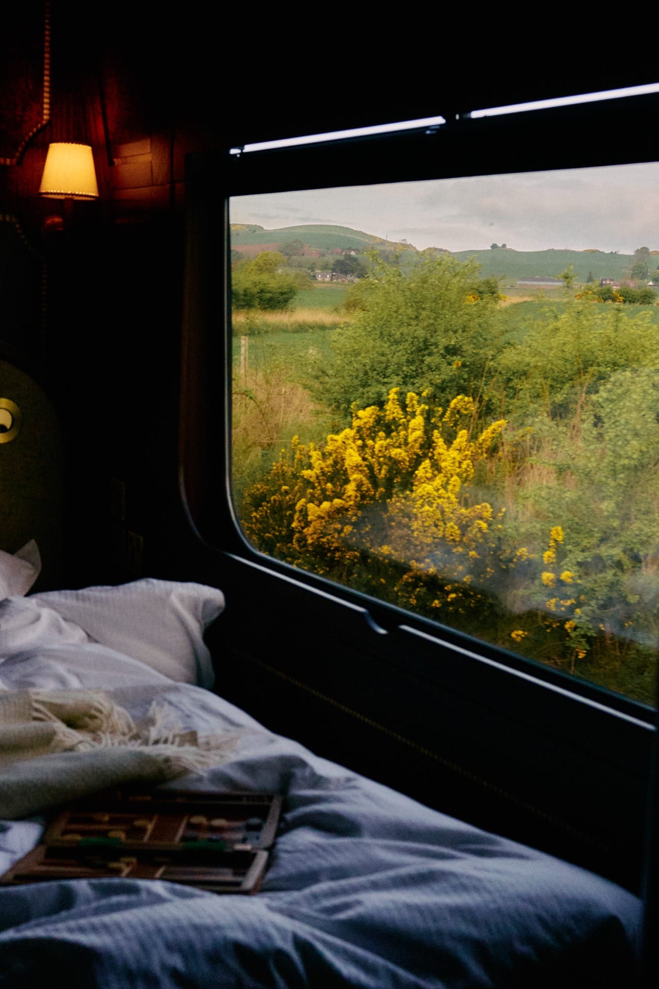 A Grand Suite aboard Royal Scotsman — the daytime lounge configuration with the double bed, mahogany marquetry, and picture window.