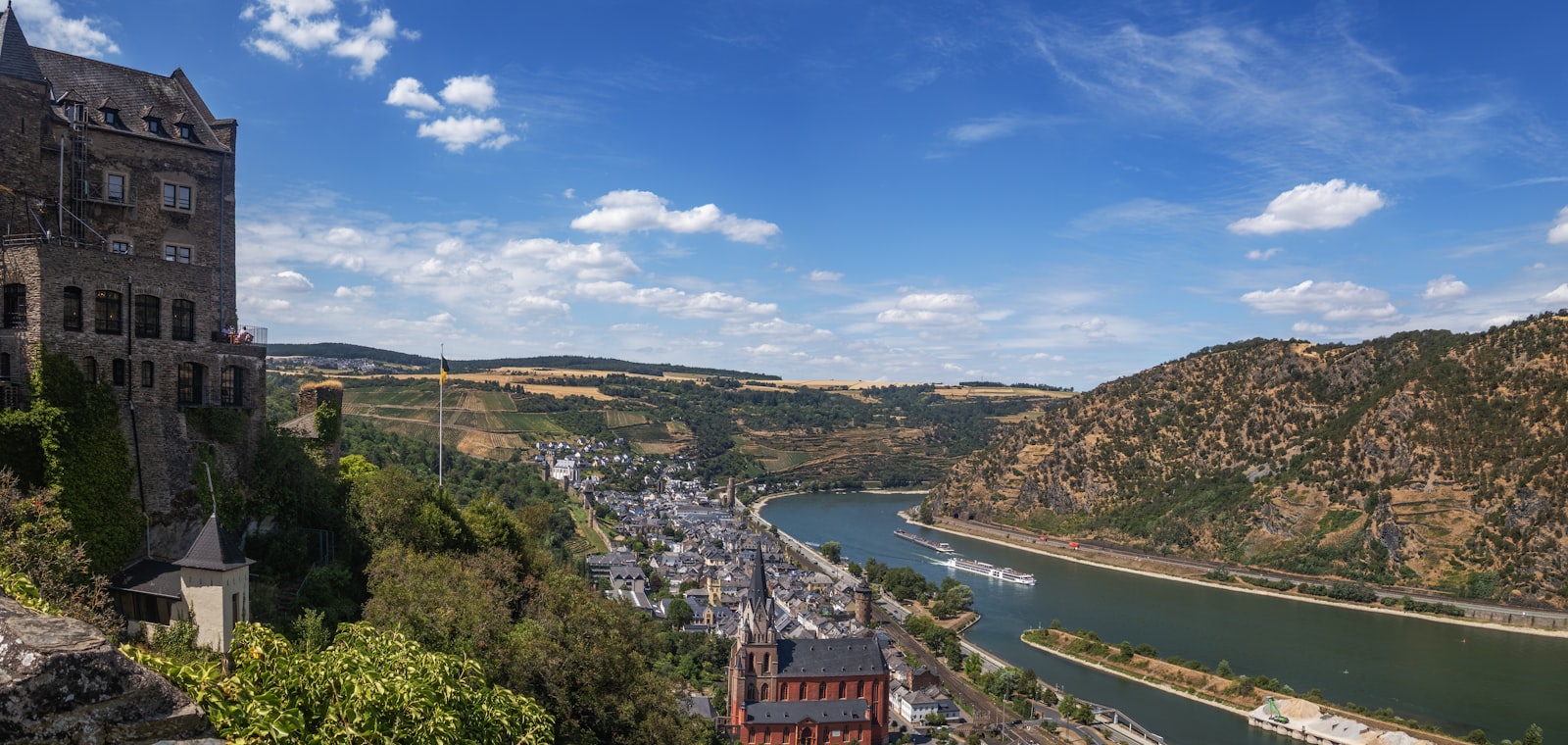 A castle overlooking a river and town in the Rhine valley, Germany.