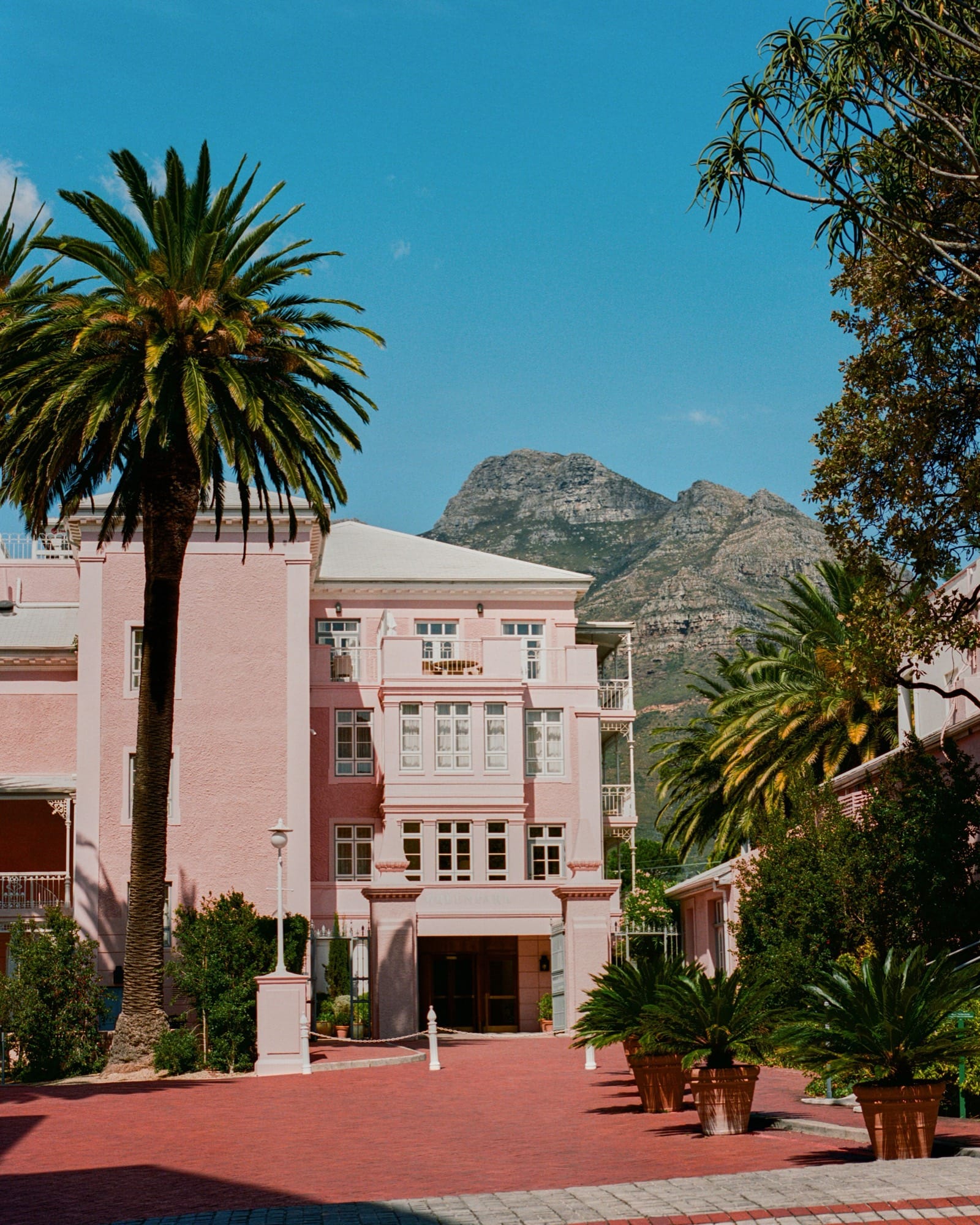 Mount Nelson's pink facade framed by palms, with Table Mountain's ridge behind