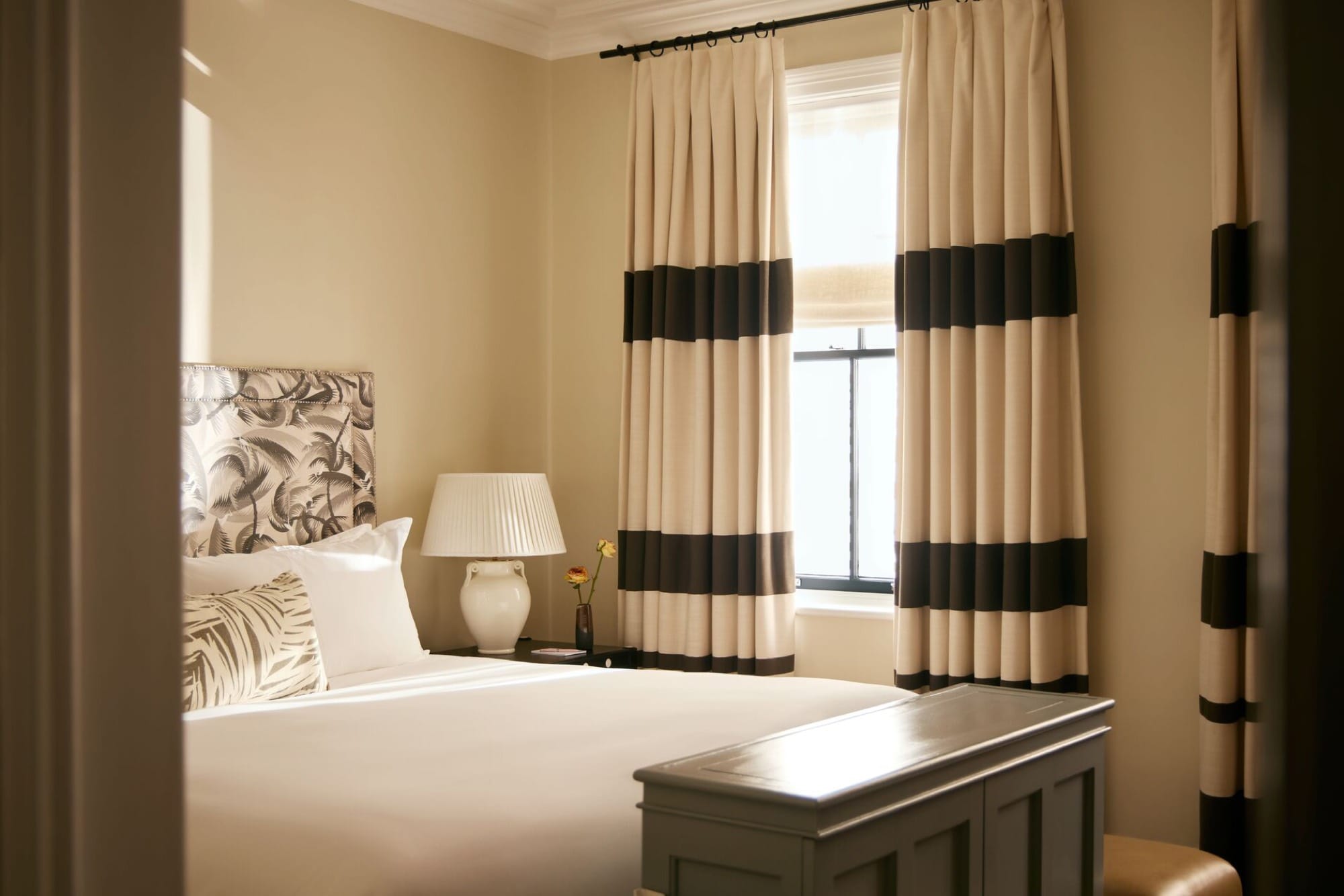 A bedroom at Mount Nelson with a canopy bed, a writing desk, and a view onto the rose garden.