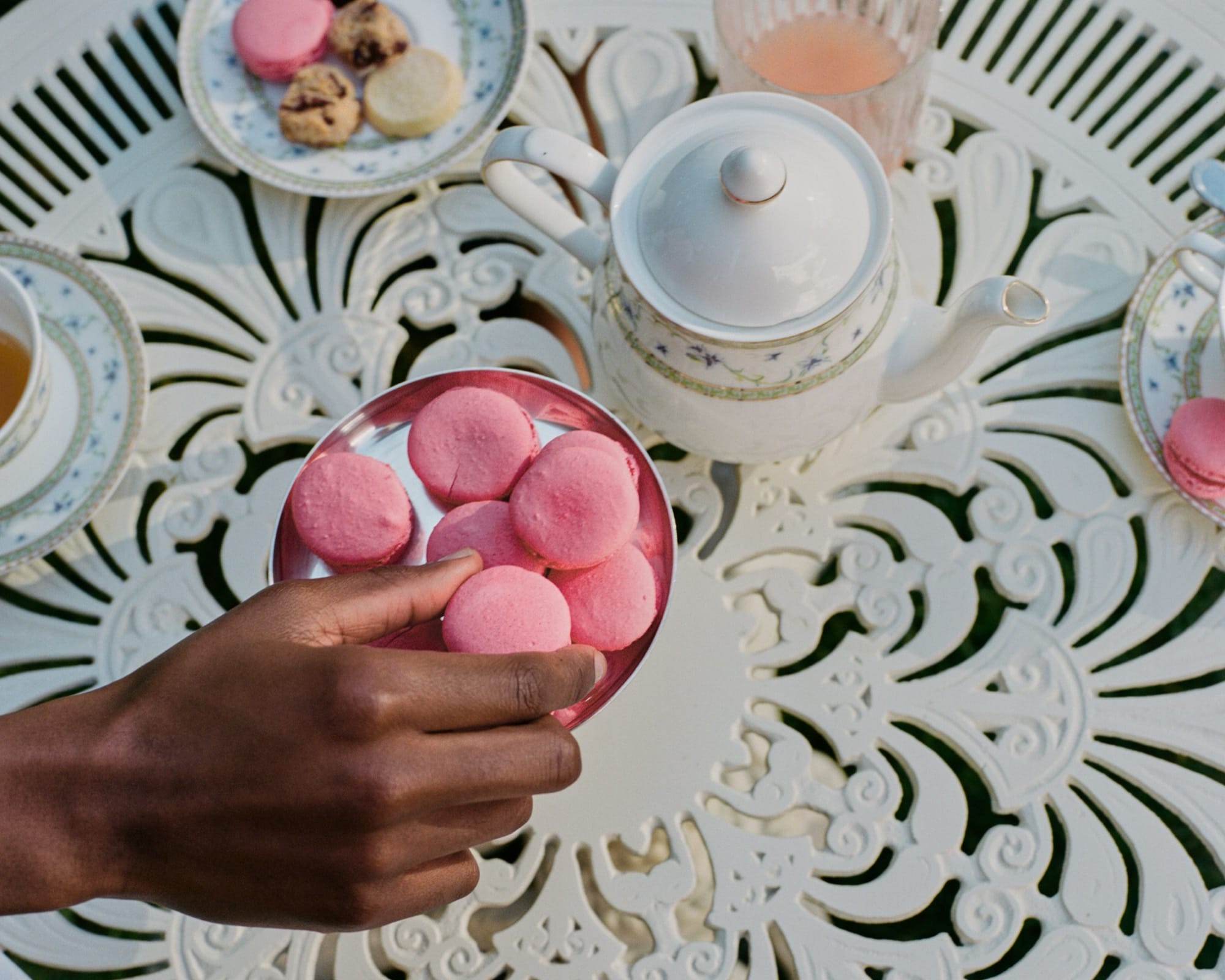 A tea service moment at Mount Nelson — pot pouring, cake plates in the foreground.