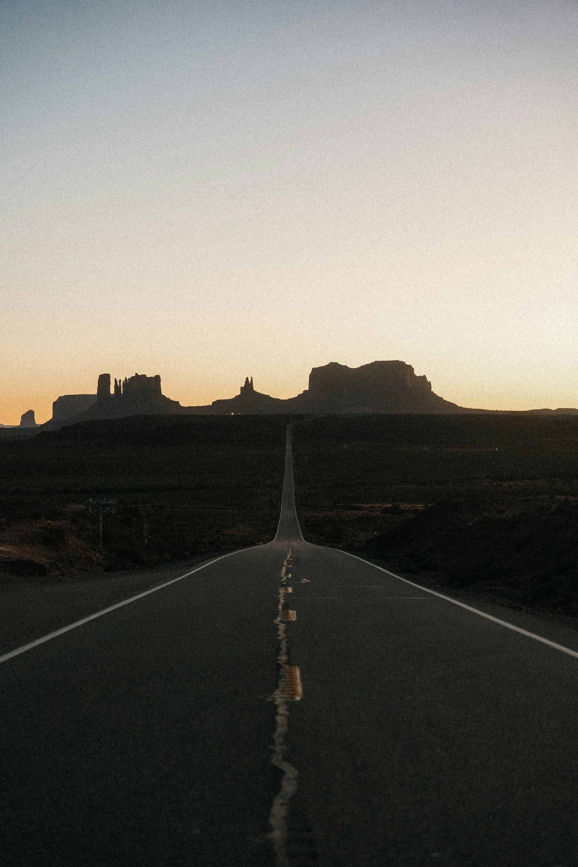 Desert highway leading to Monument Valley at sunset, American Southwest