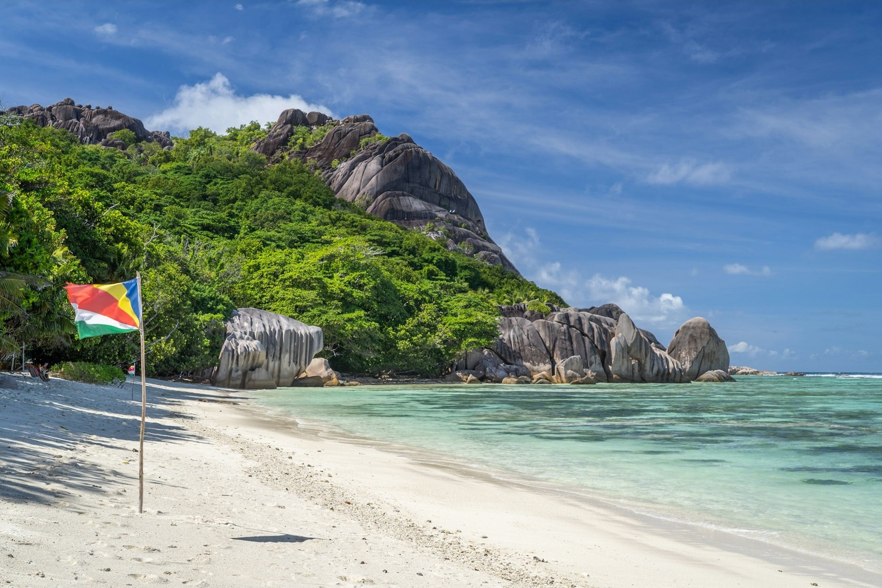 Granite boulders rising over a white-sand beach and turquoise shallows, Seychelles