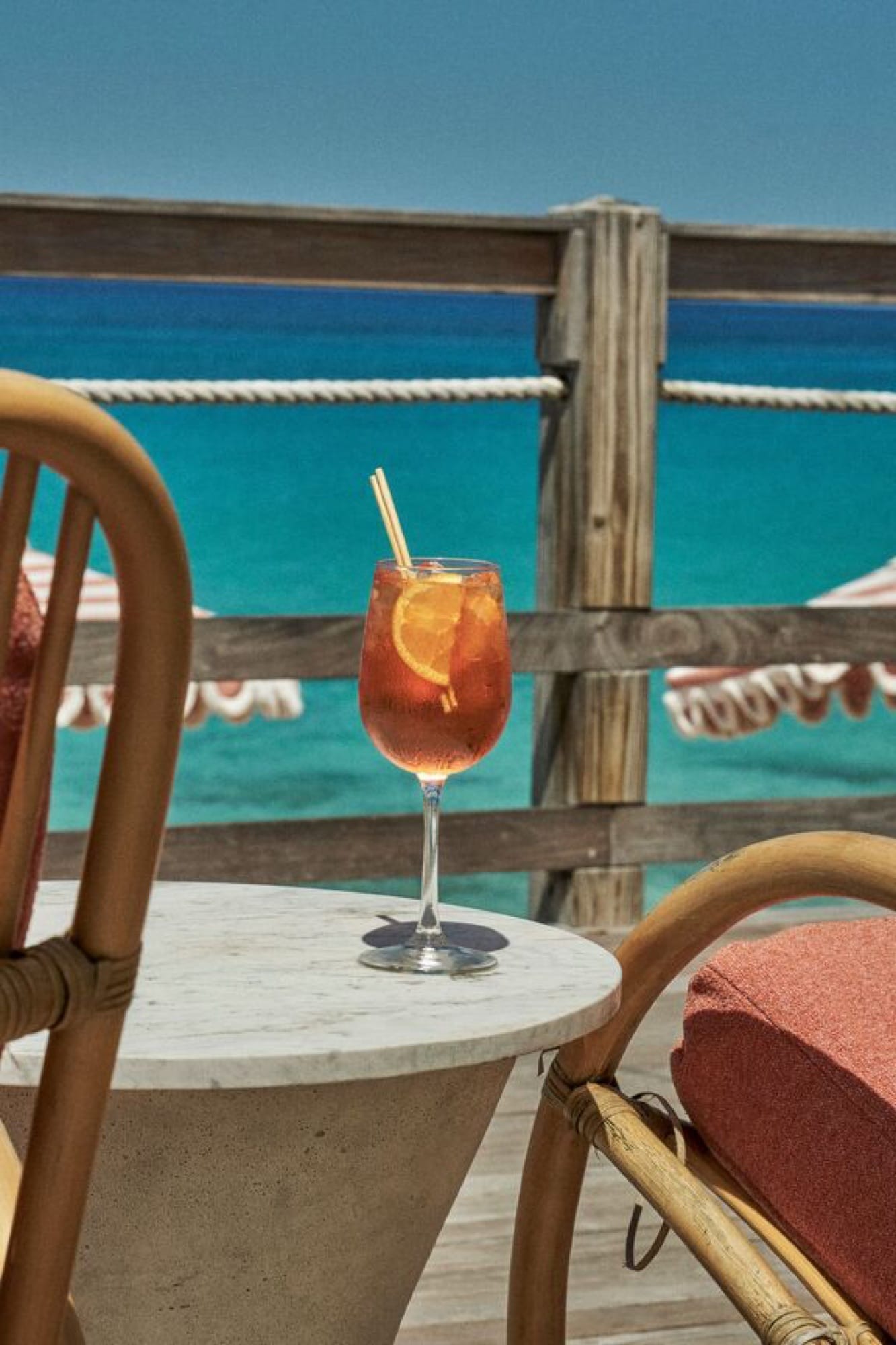 The bar at La Samanna — open to the beach, set for sunset cocktails, with the curve of Baie Longue and the Caribbean horizon beyond.