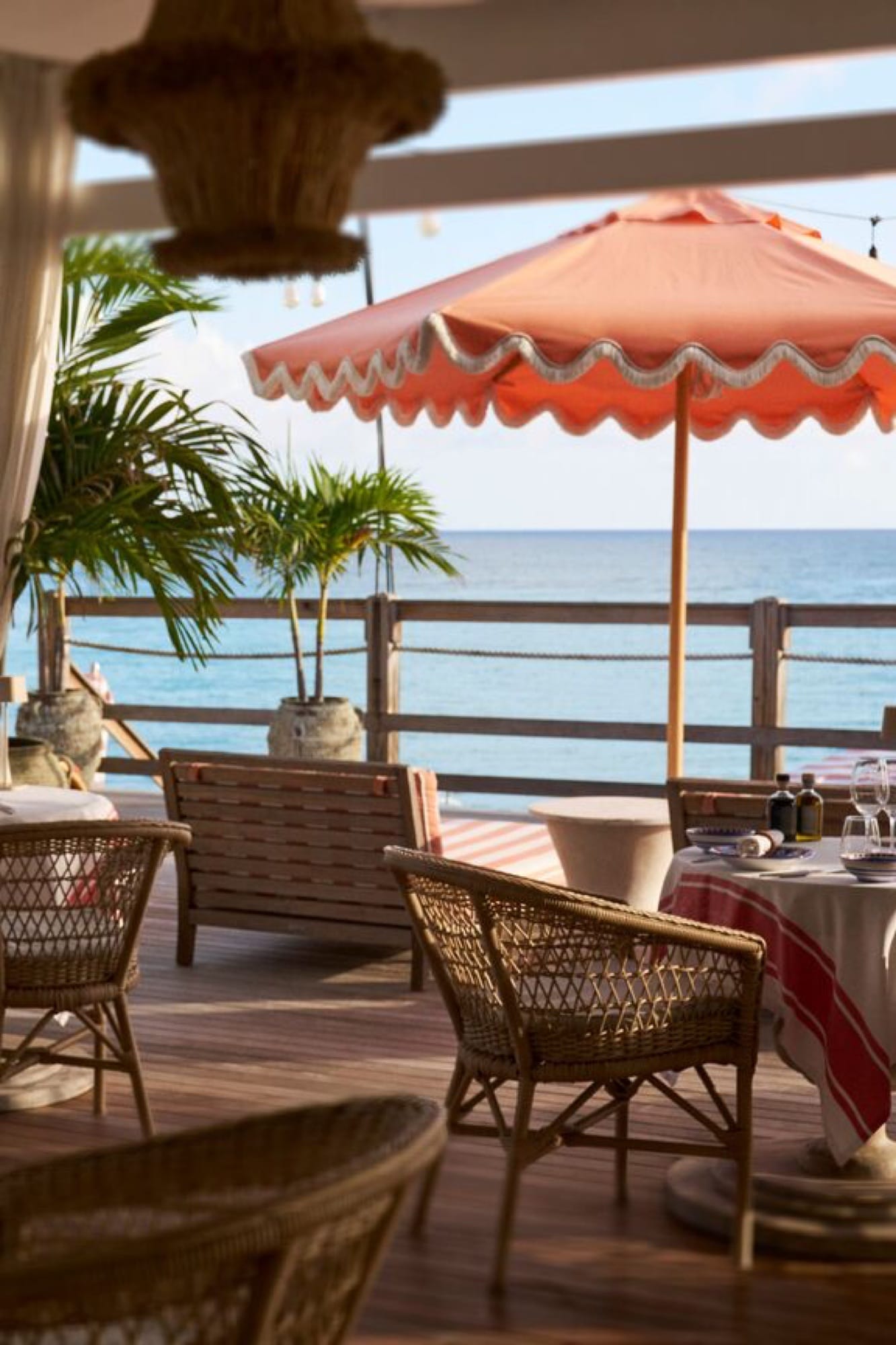 The main restaurant at La Samanna, table set for evening with white linens and the Caribbean as the view.