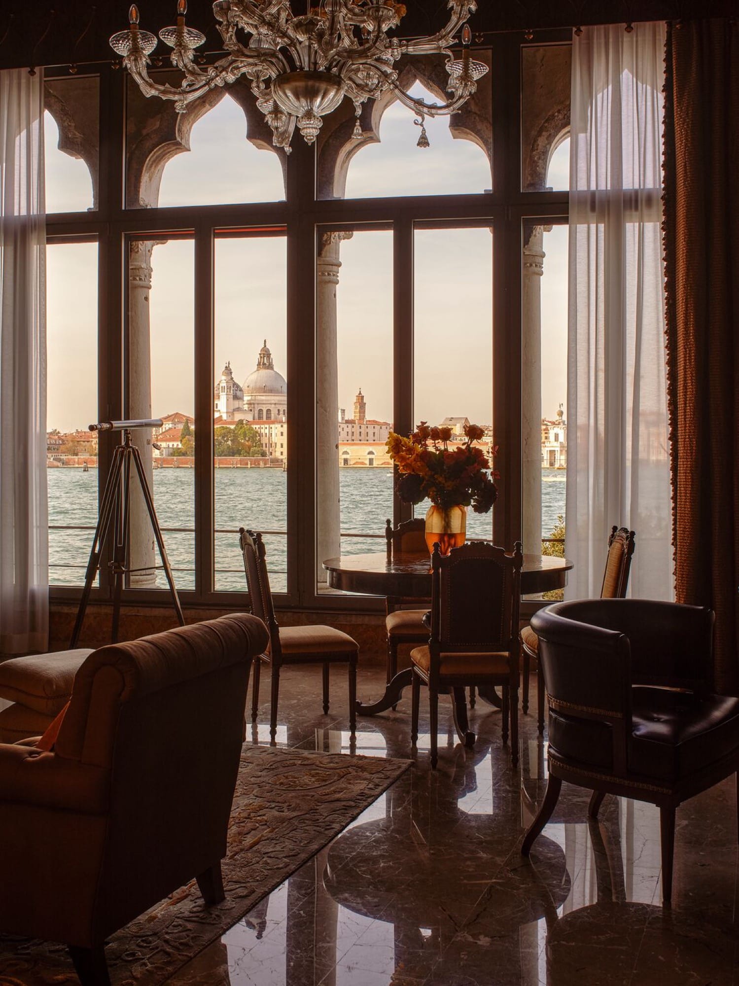 A Cipriani suite living room with classical Venetian furnishings and lagoon-facing windows.