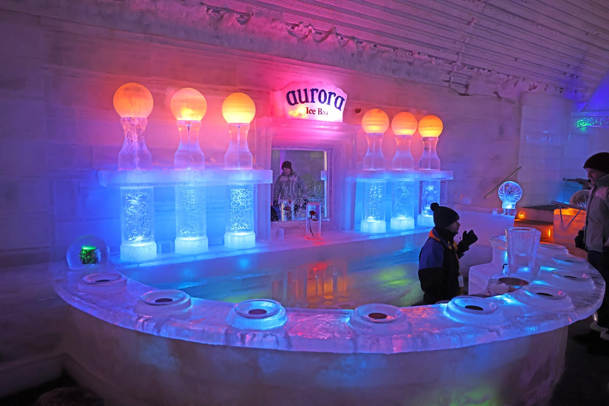 The illuminated ice bar inside the Aurora Ice Museum at Chena Hot Springs, carved entirely from ice and lit in blue and amber.