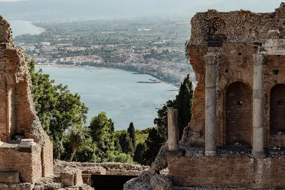 The sea at Taormina framed through the stone arches of the ancient Greek theatre.