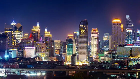 The illuminated Bangkok skyline at night with the Chao Phraya River winding through the city