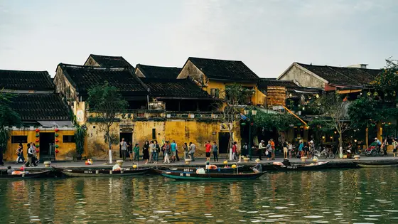 The yellow riverfront shophouses and traditional boats of Hoi An old town on the Thu Bon River, Vietnam