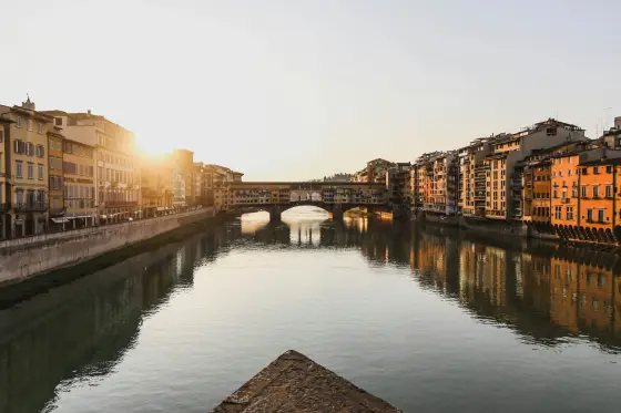 Historic buildings along the Arno River at golden hour in Florence, Italy