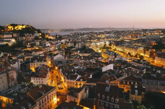 Pastel hillside houses and terracotta rooftops above the Tagus River in Lisbon