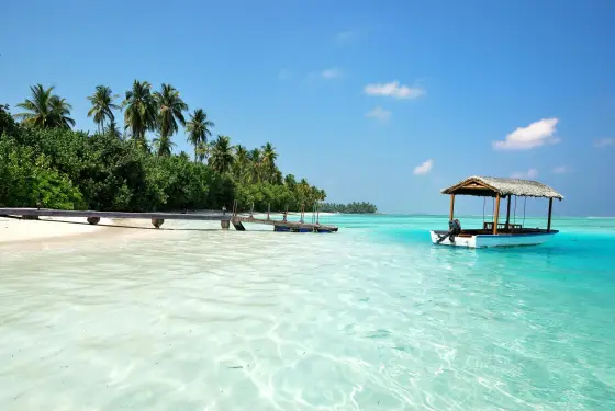 An overwater villa above a clear turquoise lagoon in the Maldives