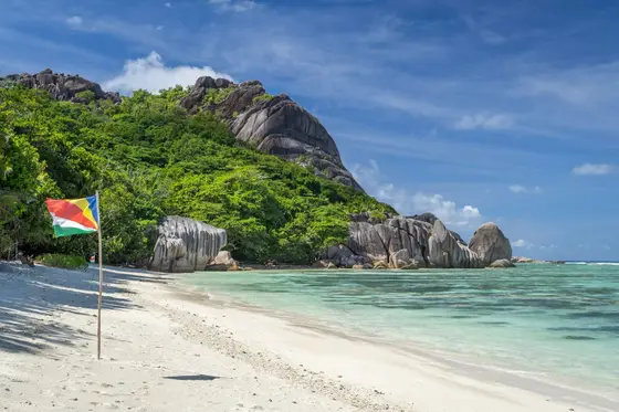Granite boulders rising over a white-sand beach and turquoise shallows, Seychelles
