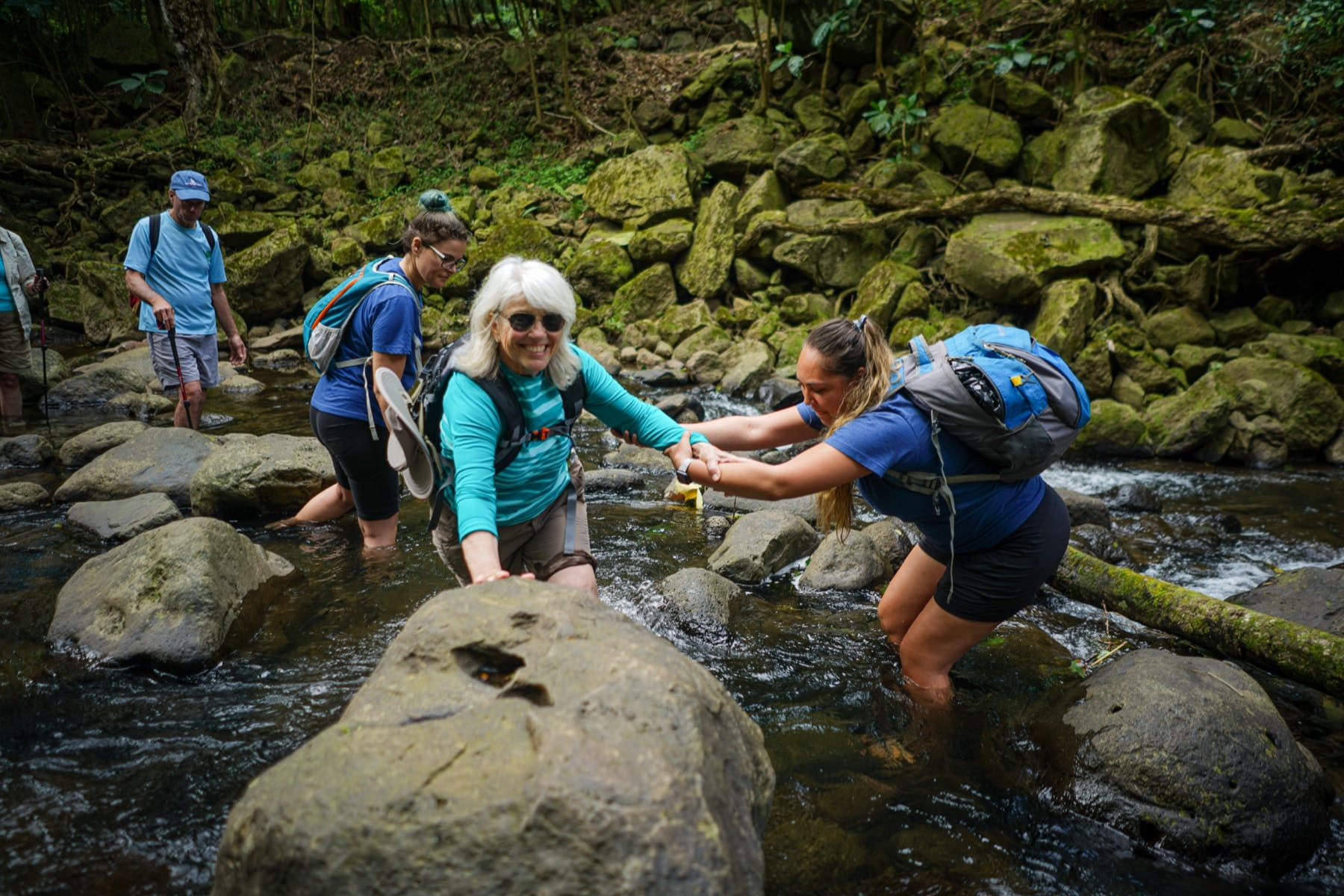 Crossing a stream in Halawa Valley on Molokai during an UnCruise shore excursion — the kind of small-island access big ships can't offer.