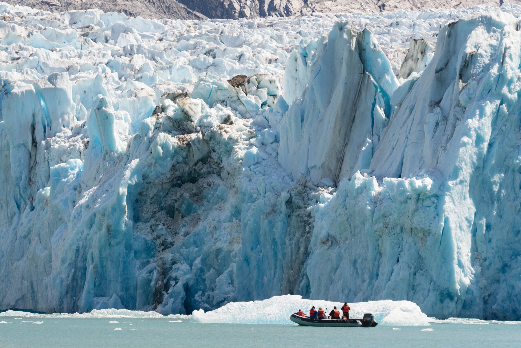 Guests in a skiff approach the face of Dawes Glacier — the wilderness encounter only a small ship can deliver.