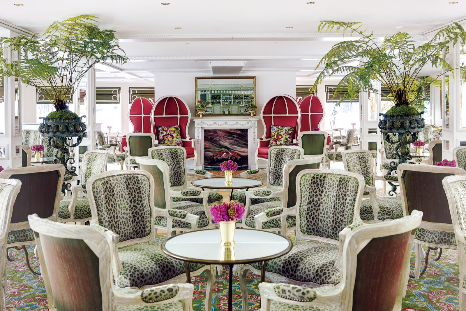 The Van Gogh Lounge aboard a Uniworld Super Ship — leopard-print bergères, a marble fireplace, and ferns in bronze urns.