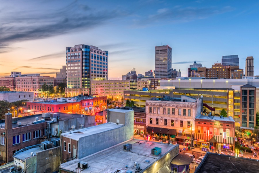 Downtown Memphis at dusk from above, office towers behind and the lit entertainment district in the foreground.