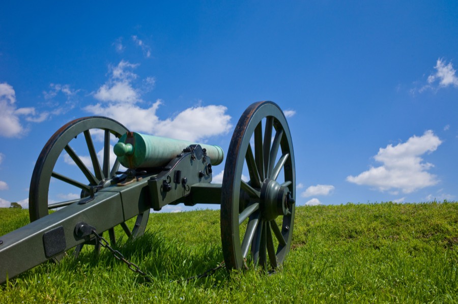 A Civil War field gun on open grass under a bright sky at Vicksburg National Military Park.
