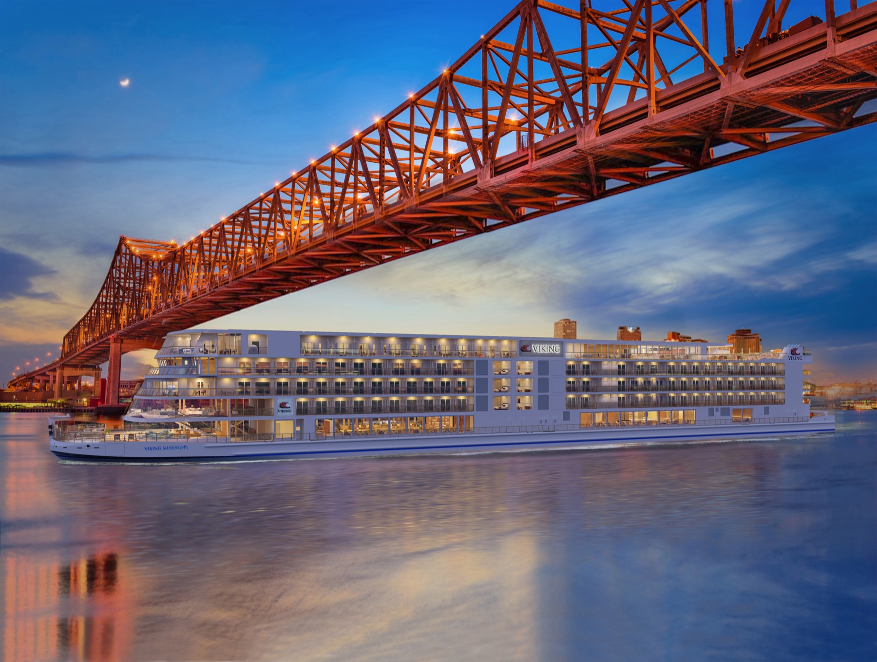 The Viking Mississippi lit at dusk on the river at New Orleans, the red steel span of the Crescent City Connection crossing above her.
