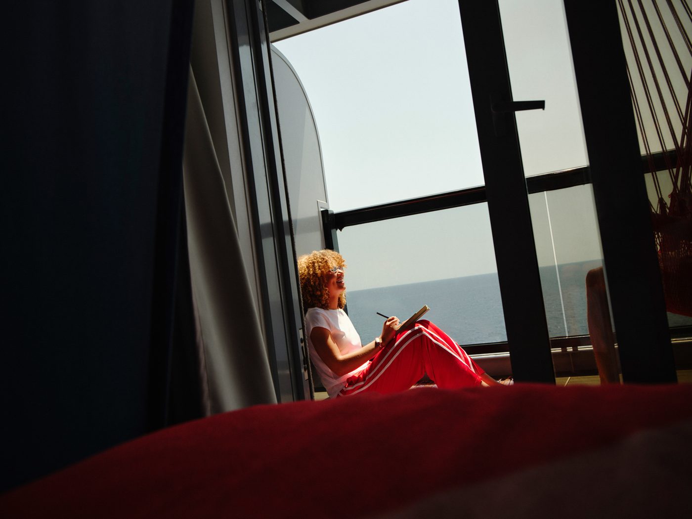 A Sea Terrace cabin by day, looking out through the glass to the terrace and the sea.