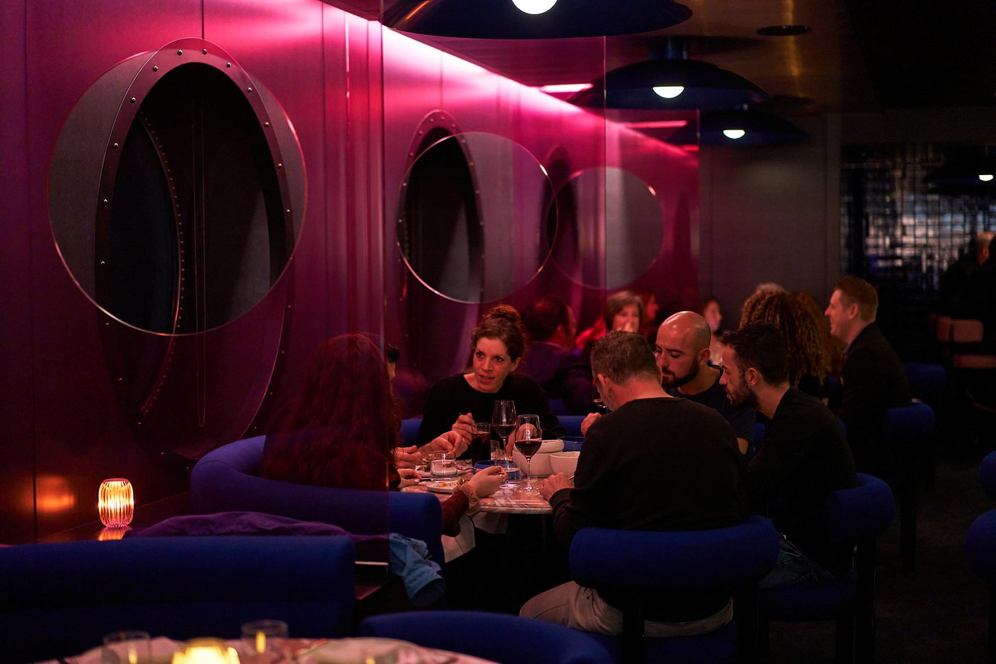 Dinner service at Pink Agave — the pink-lit dining room aboard a Virgin Voyages ship.